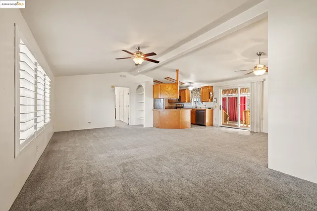 en empty room with windows and ceiling fan
