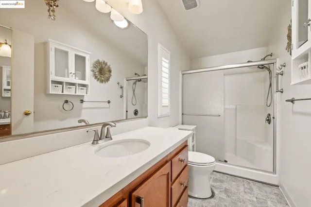 a bathroom with a sink a toilet a mirror and shower