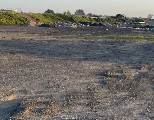 a view of a dry yard with wooden fence