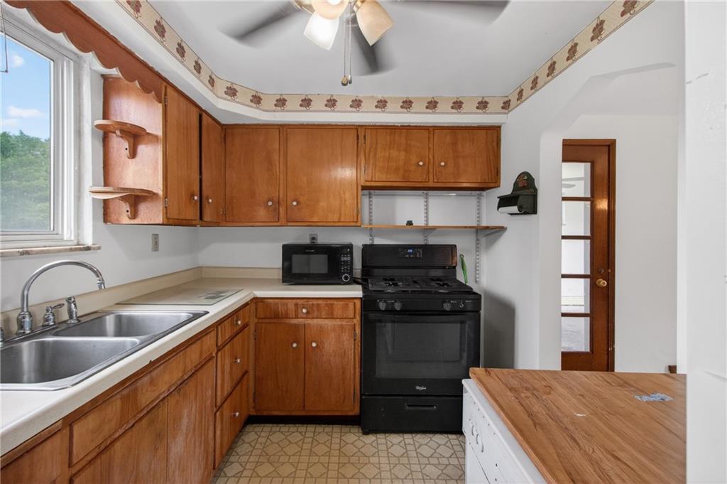 1420 Homestead Road Verona, PA 15147 - Photo 9 of 34 a kitchen with a sink stove and cabinets
