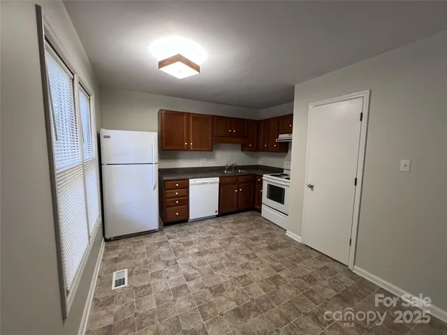 a kitchen with stainless steel appliances granite countertop a refrigerator a stove a sink and a microwave