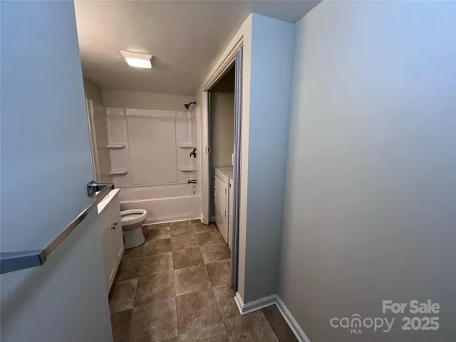 a bathroom with a granite countertop sink a toilet and shower