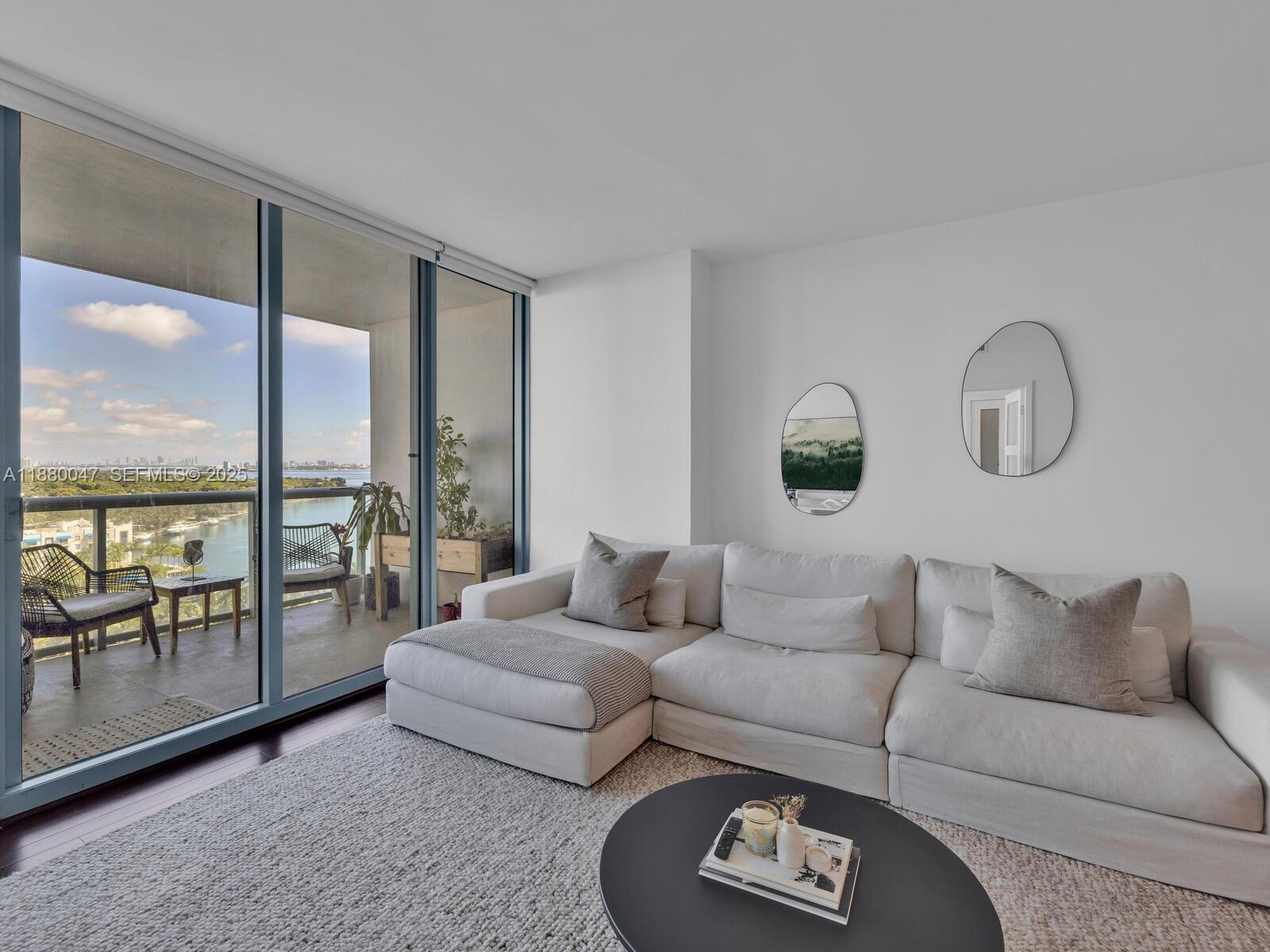 a living room with furniture and a floor to ceiling window