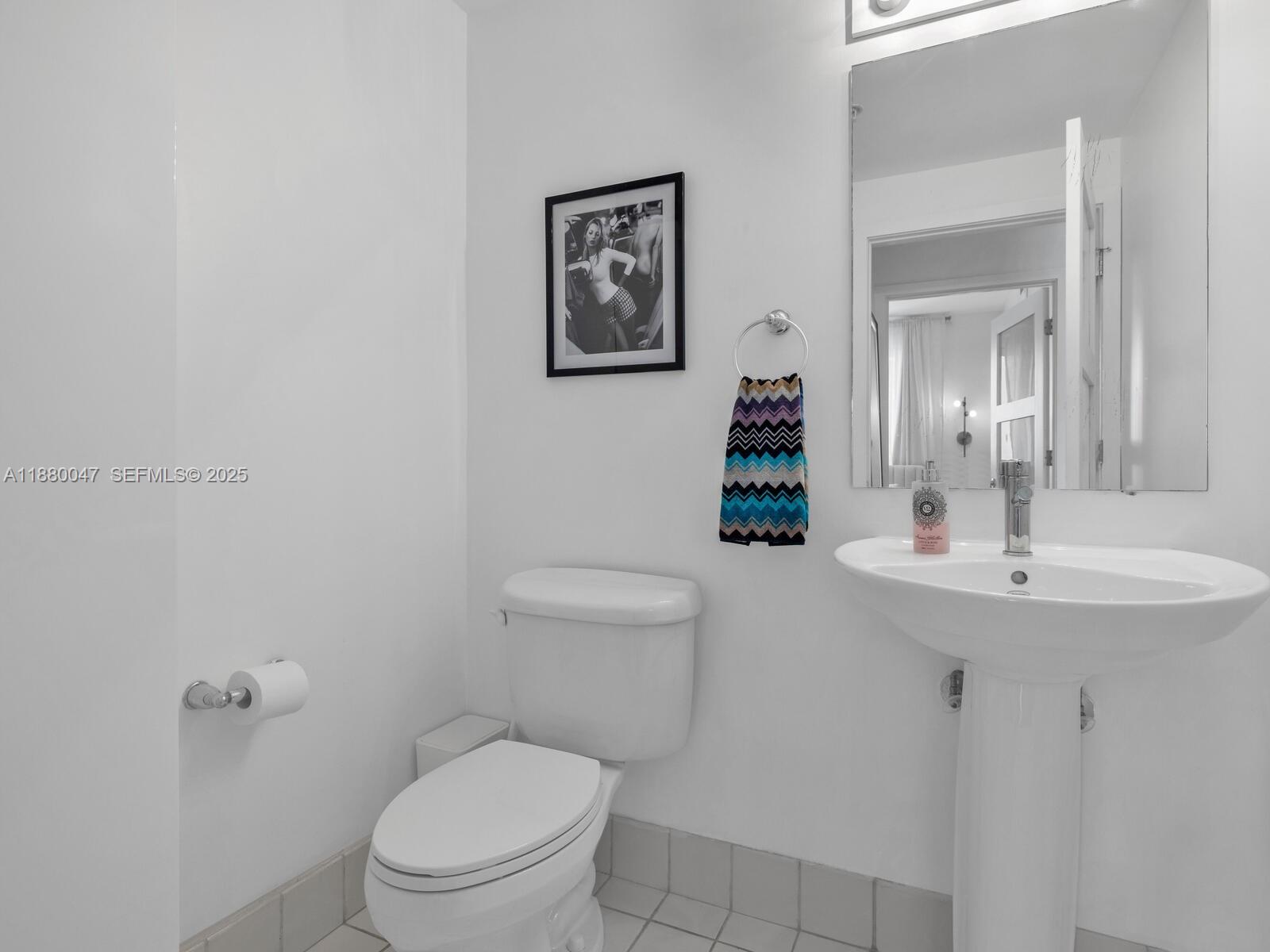 601 Northeast 36th Street, Unit 1304 Miami, FL 33137 - Photo 12 of 40 a bathroom with a toilet a sink and mirror