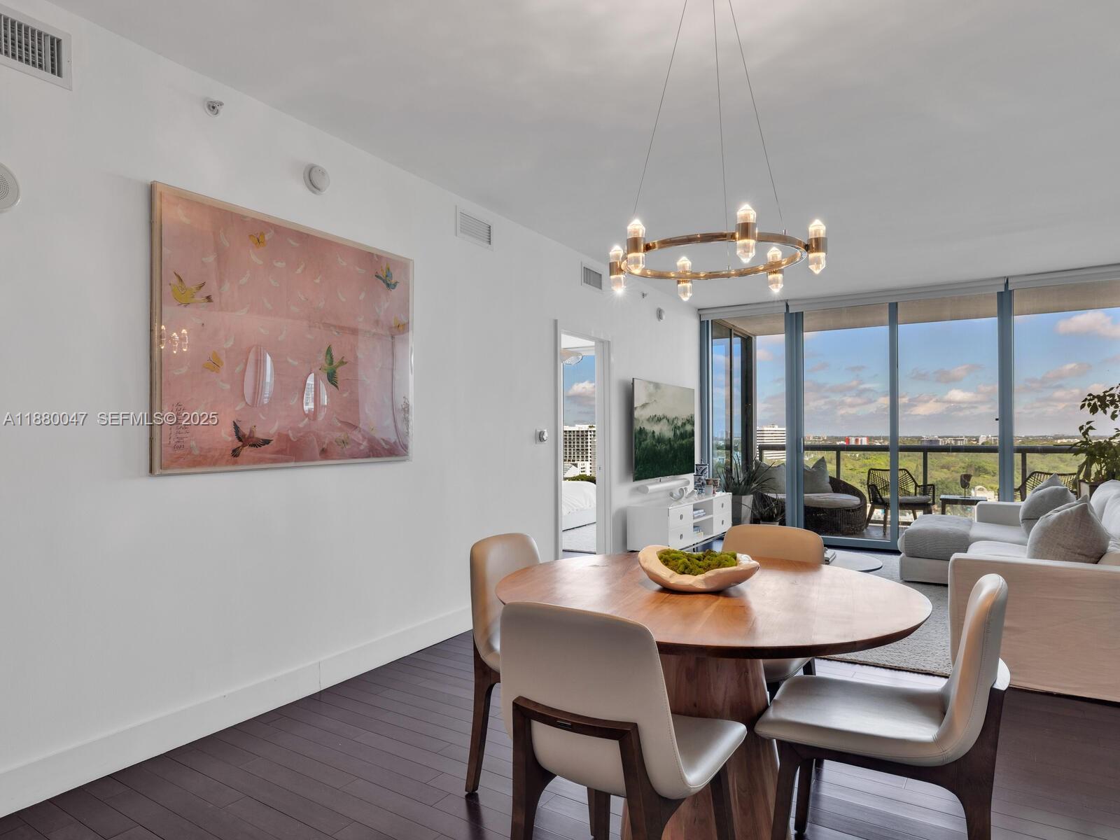 601 Northeast 36th Street, Unit 1304 Miami, FL 33137 - Photo 14 of 40 a view of a dining room with furniture a chandelier and wooden floor