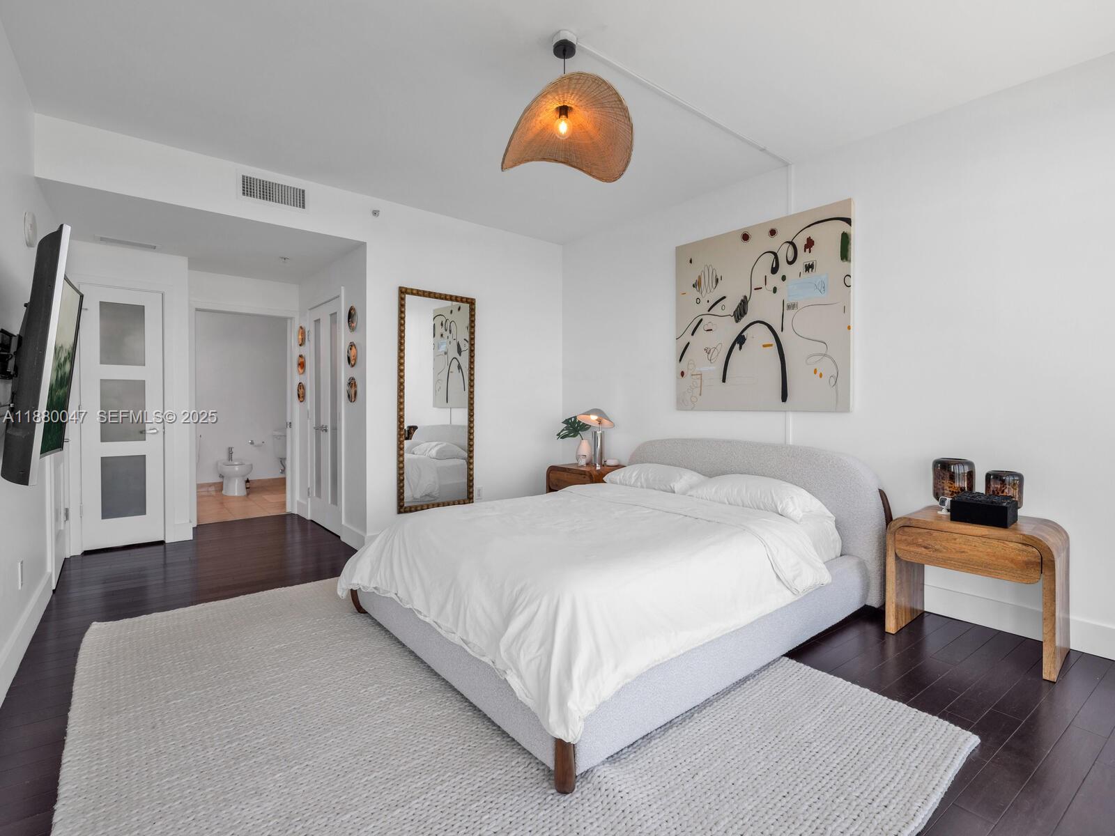 601 Northeast 36th Street, Unit 1304 Miami, FL 33137 - Photo 23 of 40 a bedroom with a bed and wooden floor