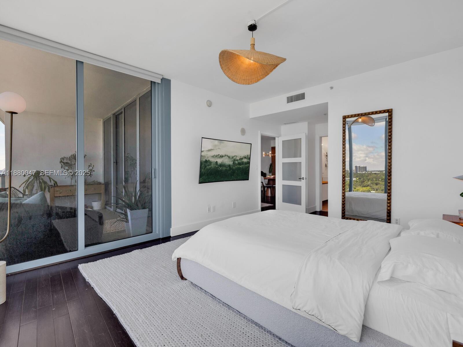 601 Northeast 36th Street, Unit 1304 Miami, FL 33137 - Photo 24 of 40 a bedroom with a large bed and wooden floor