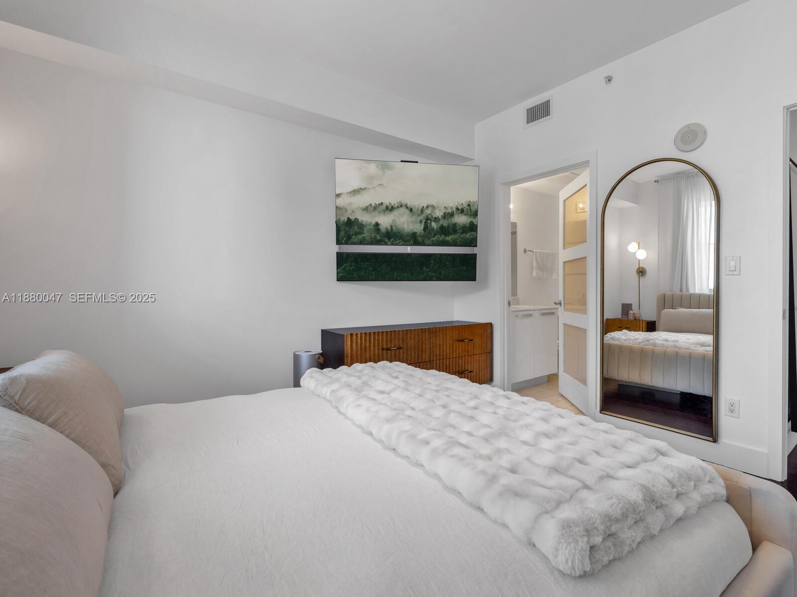 601 Northeast 36th Street, Unit 1304 Miami, FL 33137 - Photo 34 of 40 a bedroom with a bed and a view of bathroom