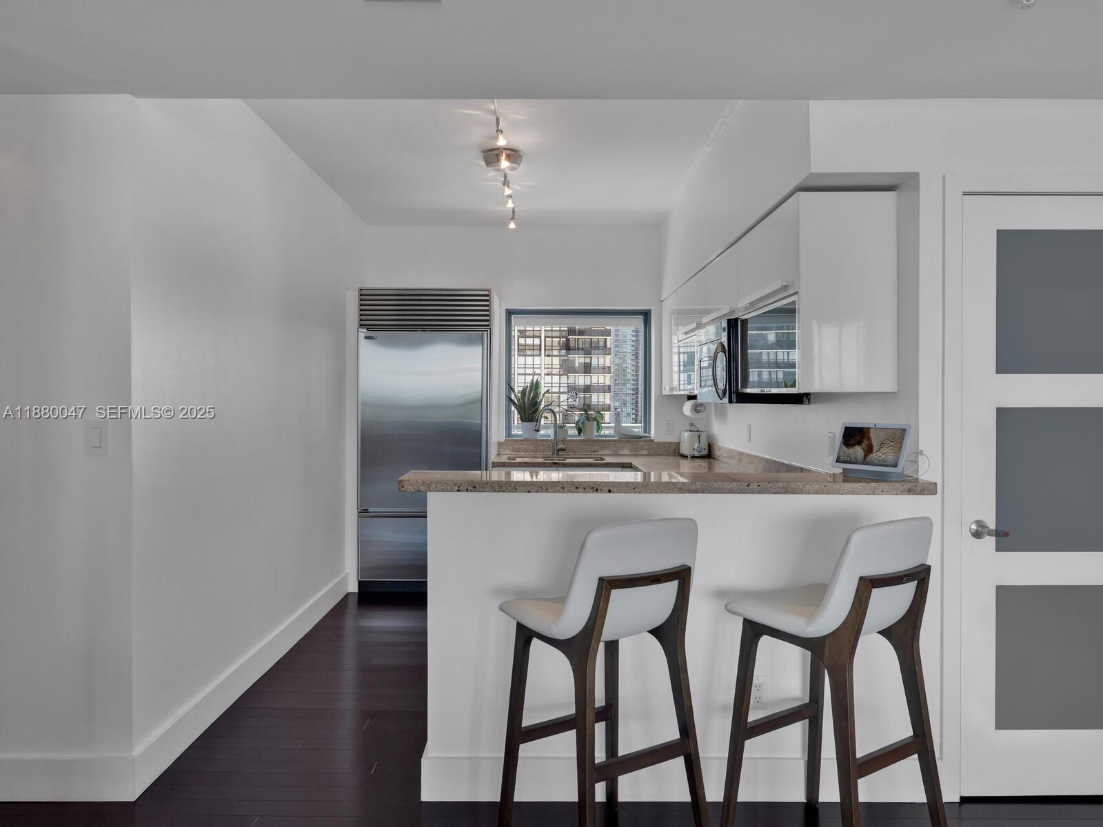 601 Northeast 36th Street, Unit 1304 Miami, FL 33137 - Photo 8 of 40 a kitchen with stainless steel appliances granite countertop a dining table chairs and granite counter tops