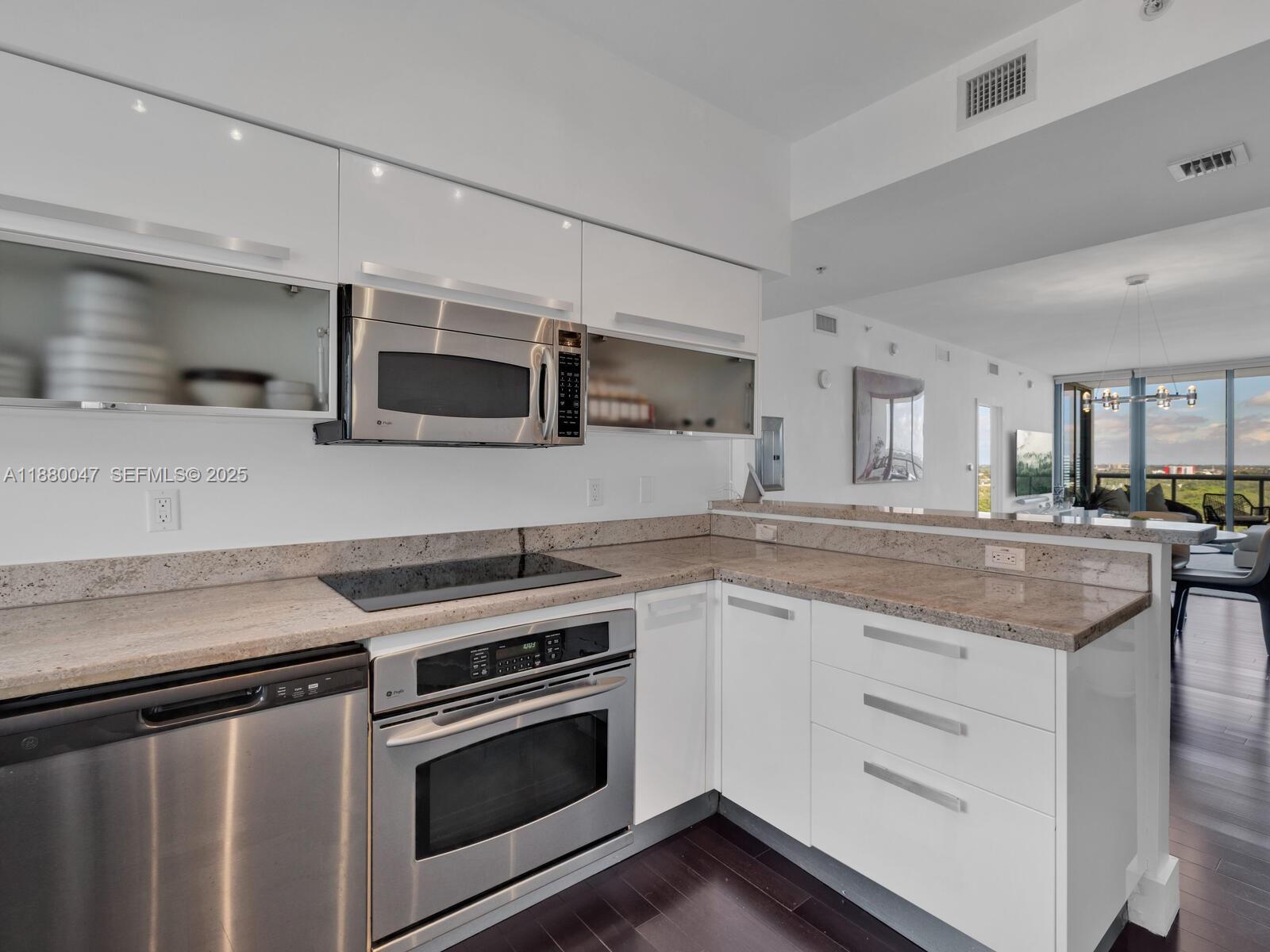 601 Northeast 36th Street, Unit 1304 Miami, FL 33137 - Photo 10 of 40 a kitchen with granite countertop a sink and steel appliances