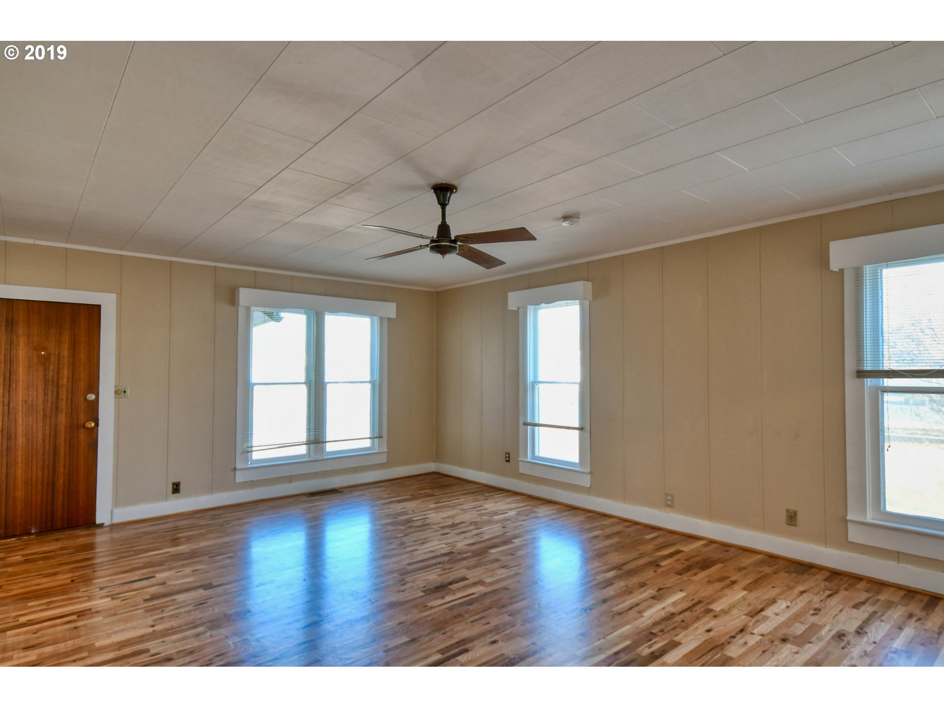 1008 Southwest Frazer Avenue Pendleton, OR 97801 - Photo 5 of 32 an empty room with wooden floor and windows