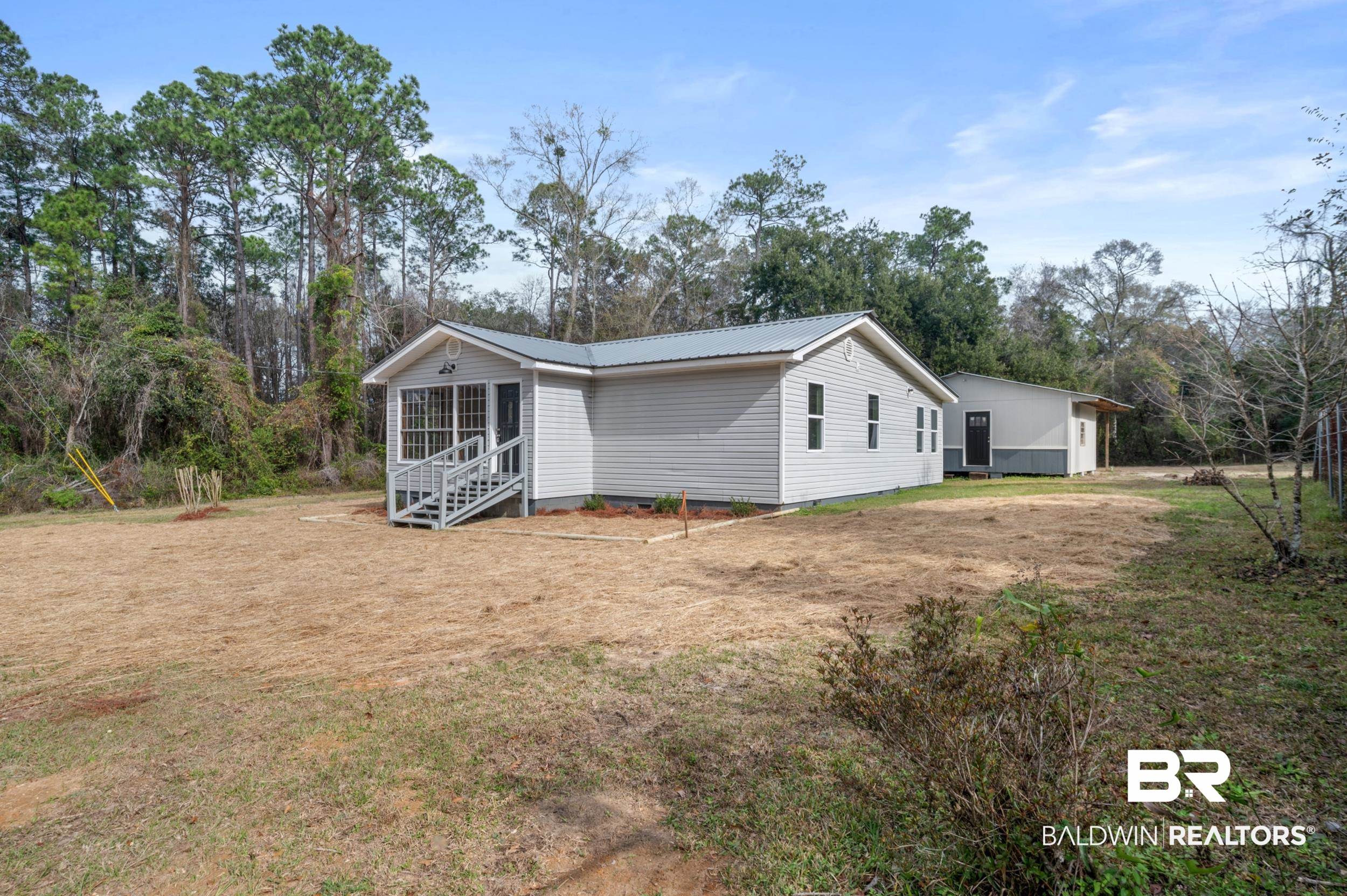 35780 Spring Road North Stapleton, AL 36578 - Photo 2 of 41 View of side of property with a lawn, a metal roof, and view of scattered trees