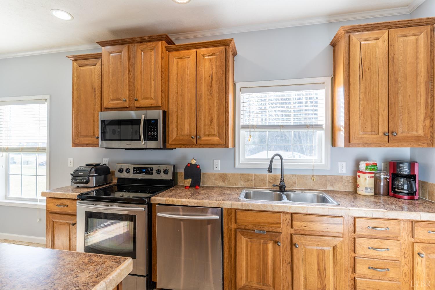 2659 Chilton Road Appomattox, VA 24522 - Photo 16 of 55 a kitchen with stainless steel appliances a stove a sink a microwave cabinets and a window