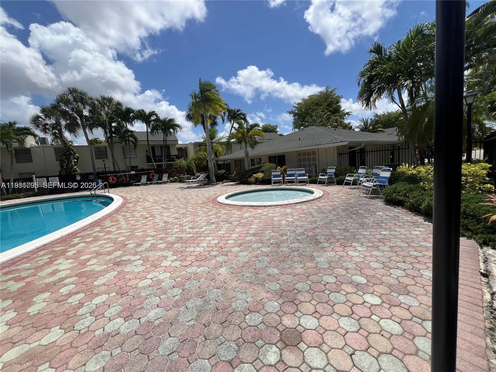 8307 Southwest 142nd Avenue, Unit F105 Miami, FL 33183 - Photo 15 of 19 a view of a house with swimming pool and a yard