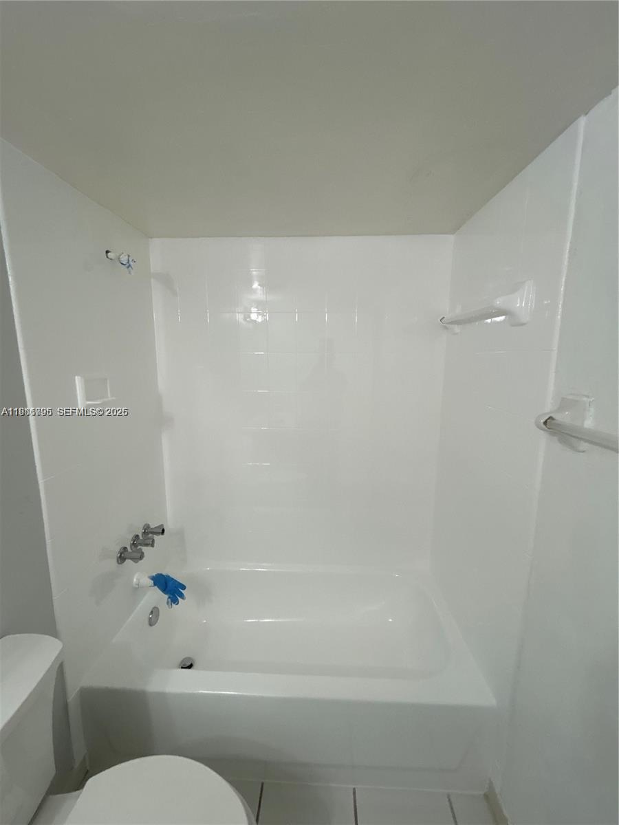 8307 Southwest 142nd Avenue, Unit F105 Miami, FL 33183 - Photo 7 of 19 a bathroom with a shower a toilet and a bathtub