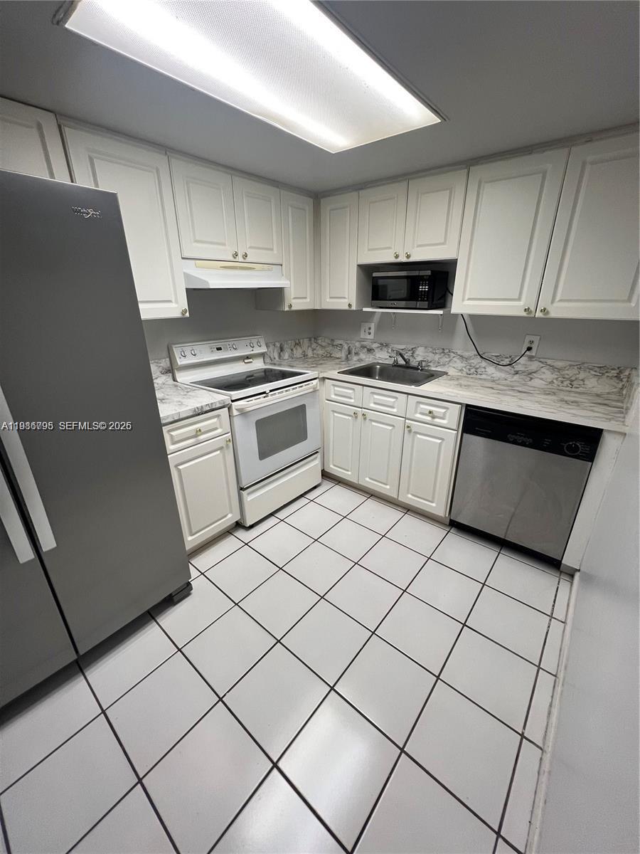 8307 Southwest 142nd Avenue, Unit F105 Miami, FL 33183 - Photo 8 of 19 a kitchen with granite countertop cabinets and steel stainless steel appliances