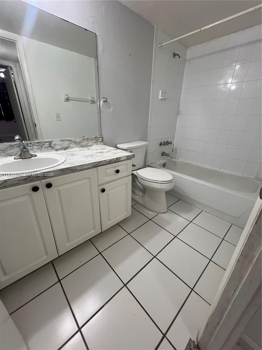 8307 Southwest 142nd Avenue, Unit F105 Miami, FL 33183 - Photo 10 of 19 a bathroom with a double vanity sink mirror and toilet