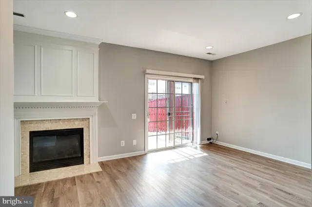 a view of a livingroom with wooden floor and a fireplace