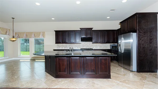 a kitchen with stainless steel appliances granite countertop wooden cabinets a sink and a stove