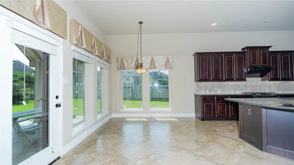 a view of an empty room with floor to ceiling windows and yard