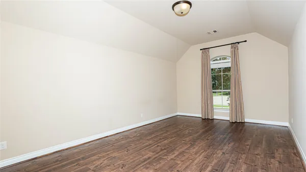 a view of an empty room with closet and a window