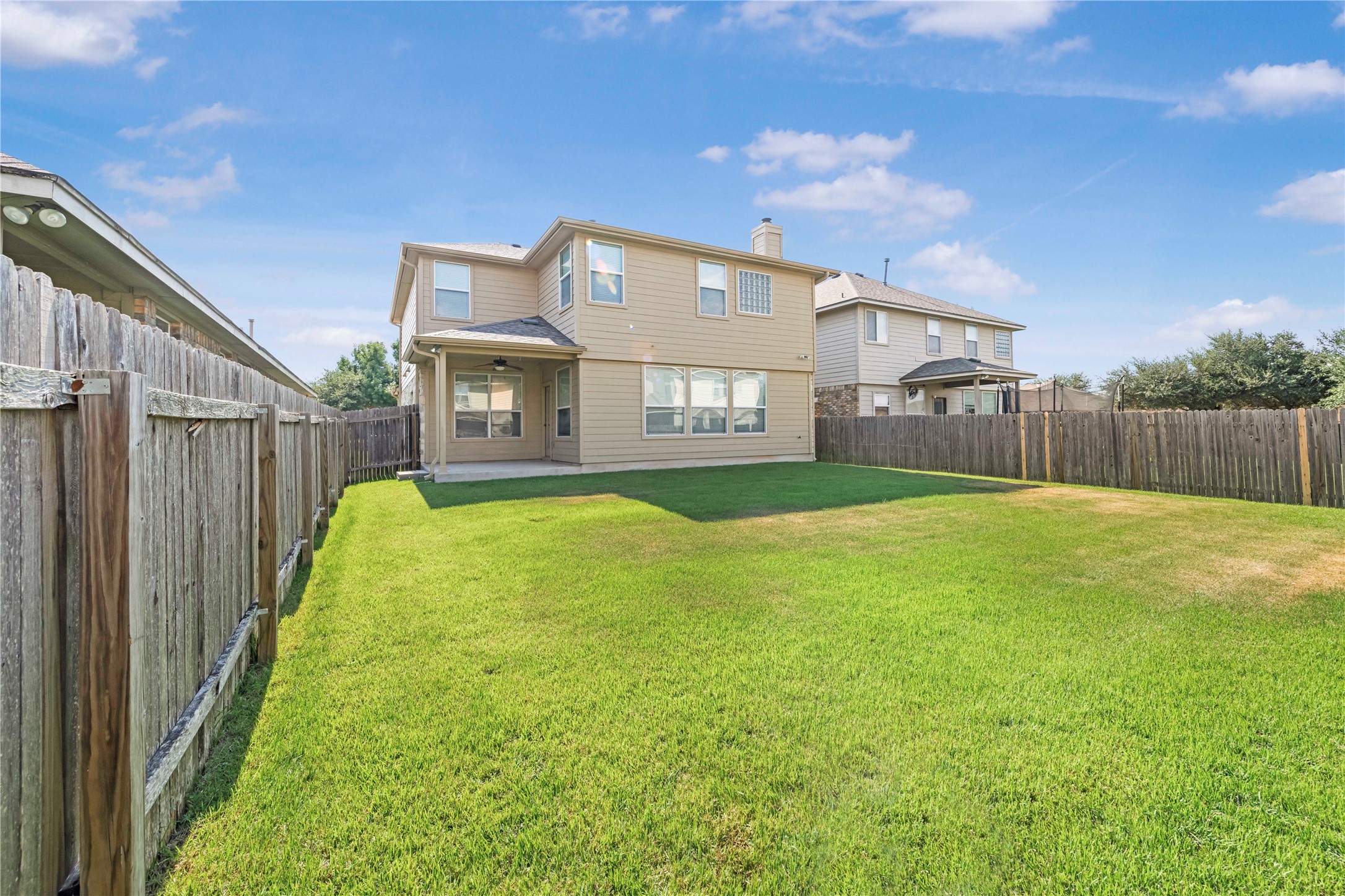 11221 Old Quarry Road Austin, TX 78717 - Photo 16 of 19 A spacious green lawn is enclosed by a privacy fence behind the two-story home.