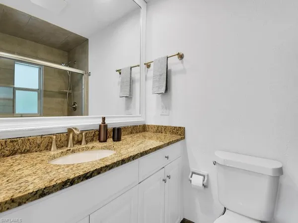 a bathroom with a granite countertop sink and a mirror