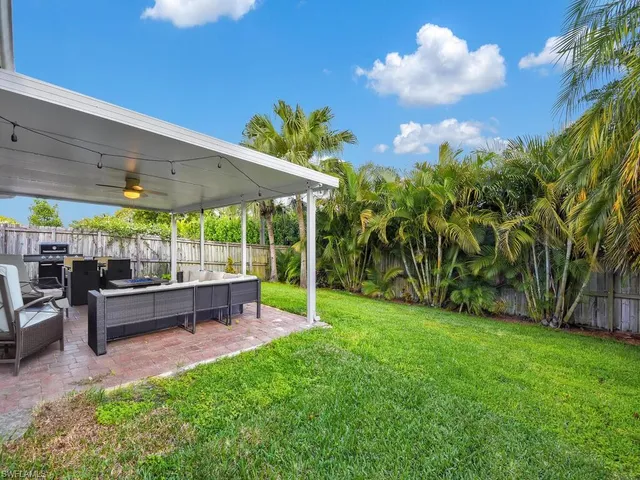 a view of a patio with table and chairs under an umbrella