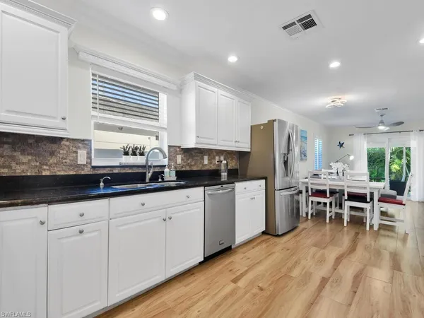 a kitchen with white cabinets sink and stainless steel appliances