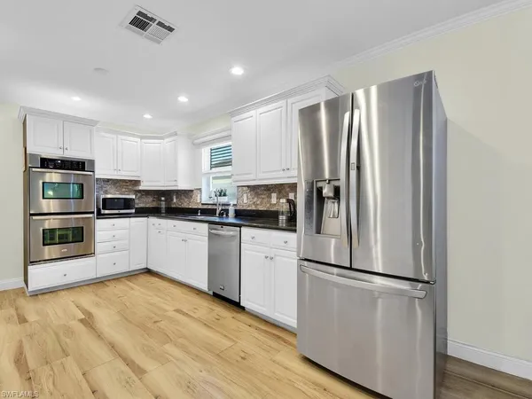 a kitchen with stainless steel appliances a refrigerator sink and microwave