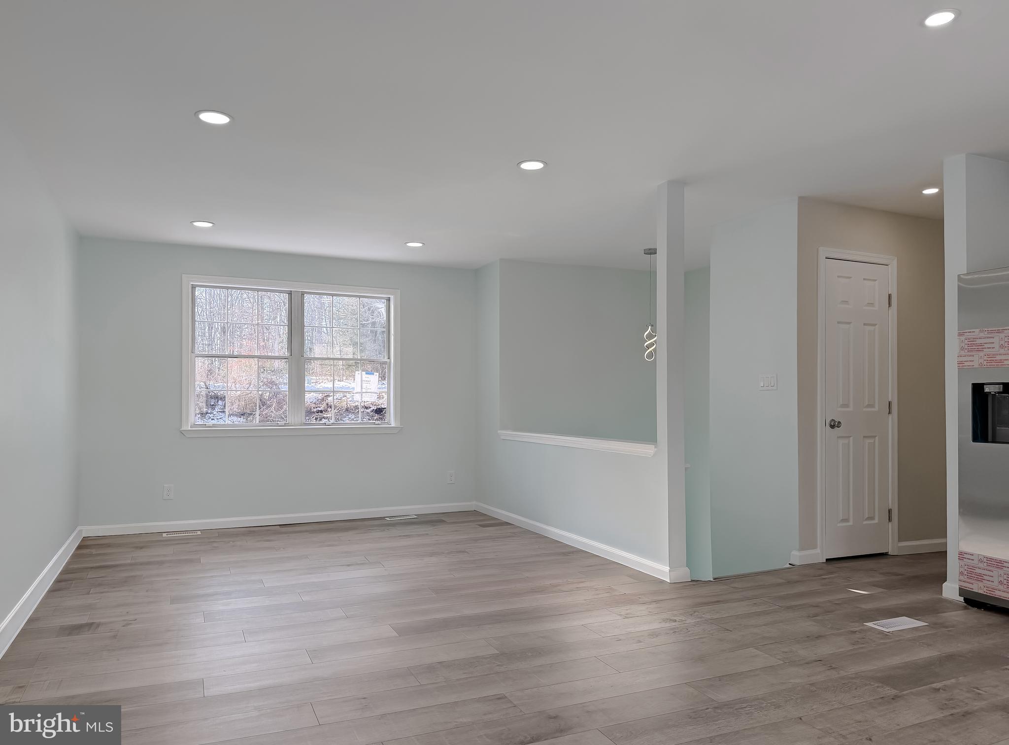 470 Sollers Wharf Road Lusby, MD 20657 - Photo 3 of 43 an empty room with wooden floor and windows