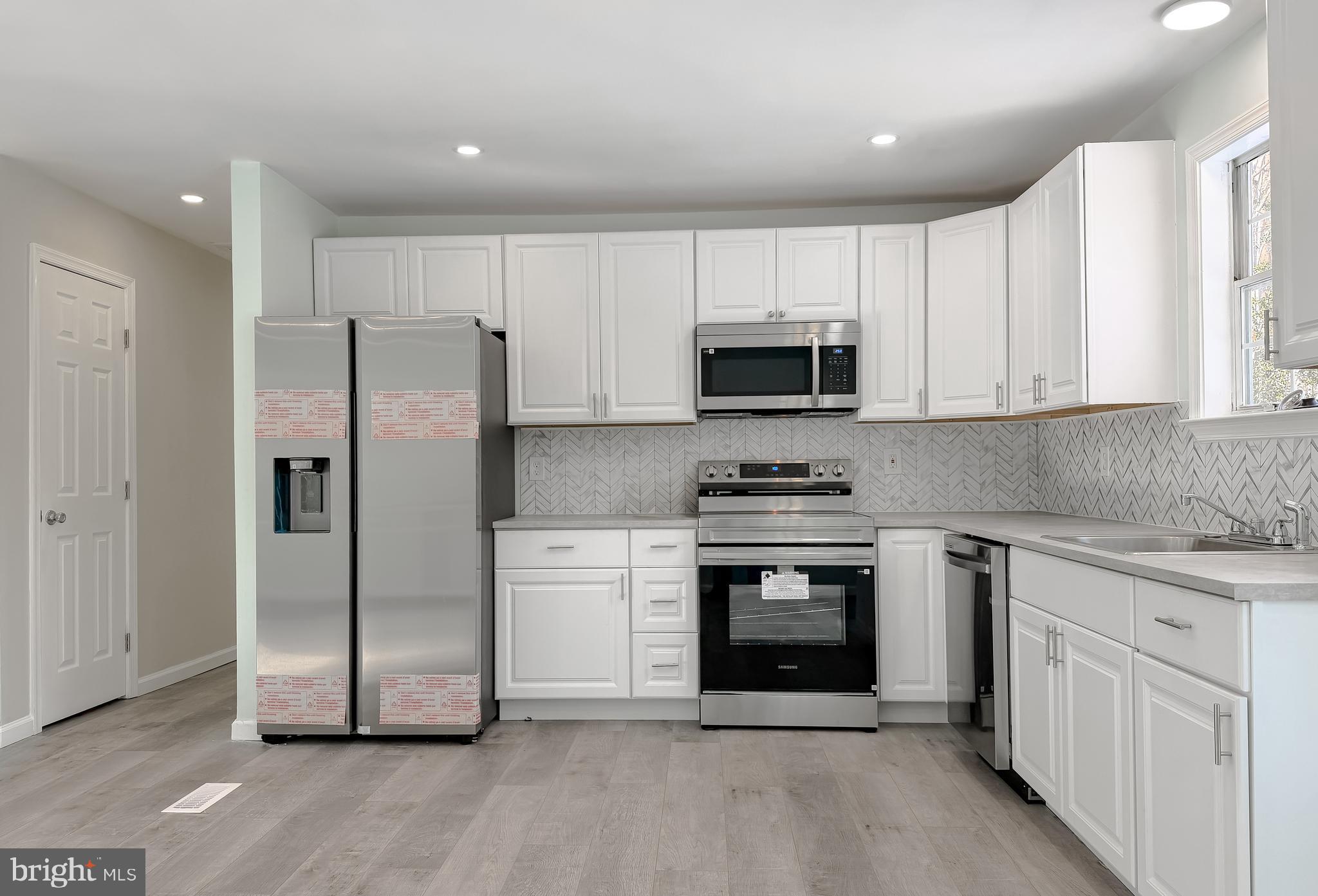 470 Sollers Wharf Road Lusby, MD 20657 - Photo 4 of 43 a kitchen with stainless steel appliances granite countertop a refrigerator a stove a sink and white cabinets