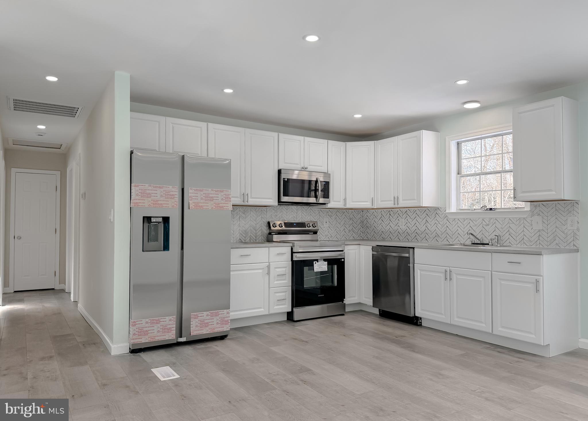 470 Sollers Wharf Road Lusby, MD 20657 - Photo 5 of 43 a kitchen with stainless steel appliances granite countertop a refrigerator a sink a stove a microwave and island