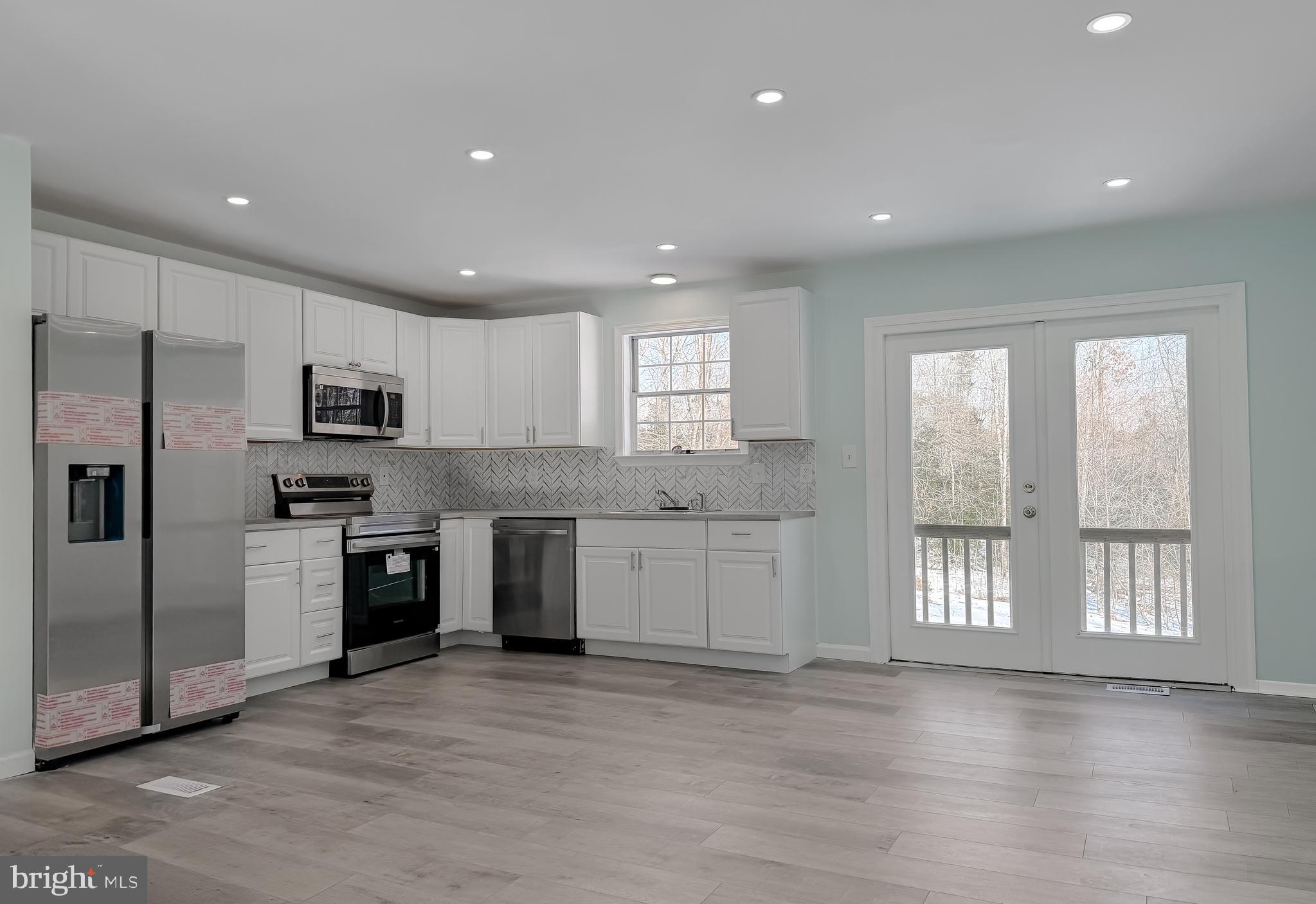 470 Sollers Wharf Road Lusby, MD 20657 - Photo 6 of 43 a large kitchen with stainless steel appliances granite countertop a refrigerator and a stove top oven
