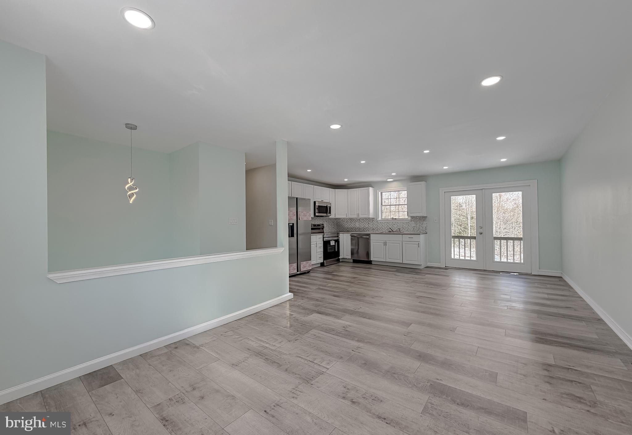 470 Sollers Wharf Road Lusby, MD 20657 - Photo 7 of 43 an empty room with wooden floor and windows