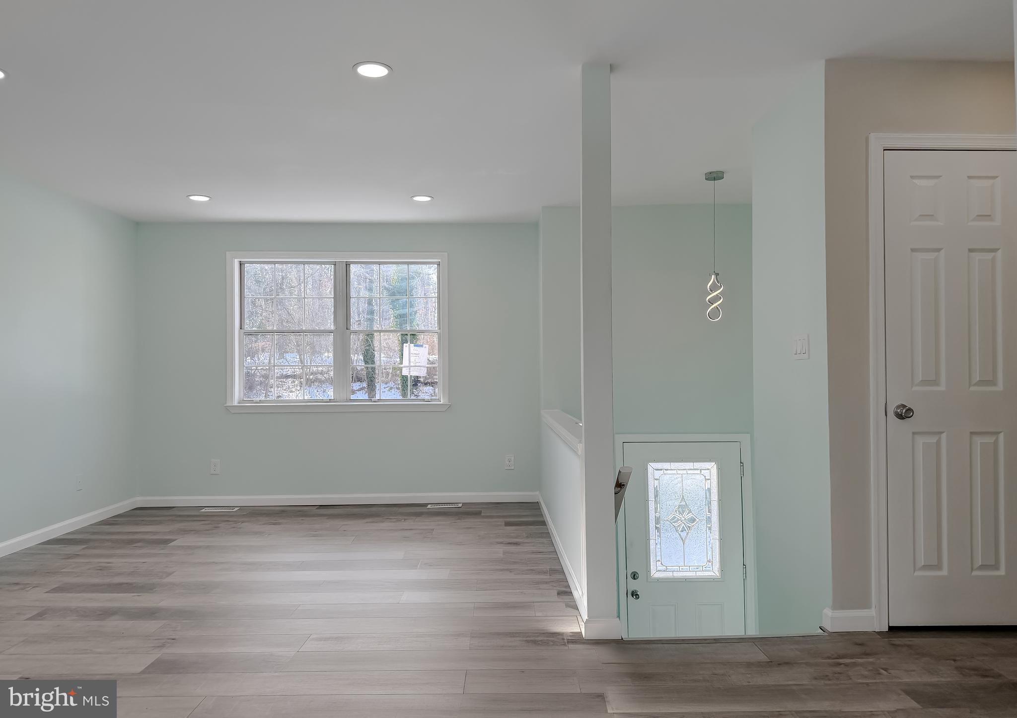 470 Sollers Wharf Road Lusby, MD 20657 - Photo 9 of 43 an empty room with wooden floor and windows