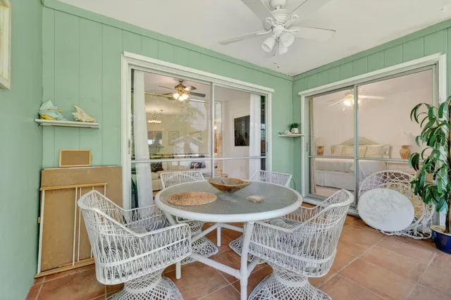 a dining room with furniture a rug a potted plant and a chandelier