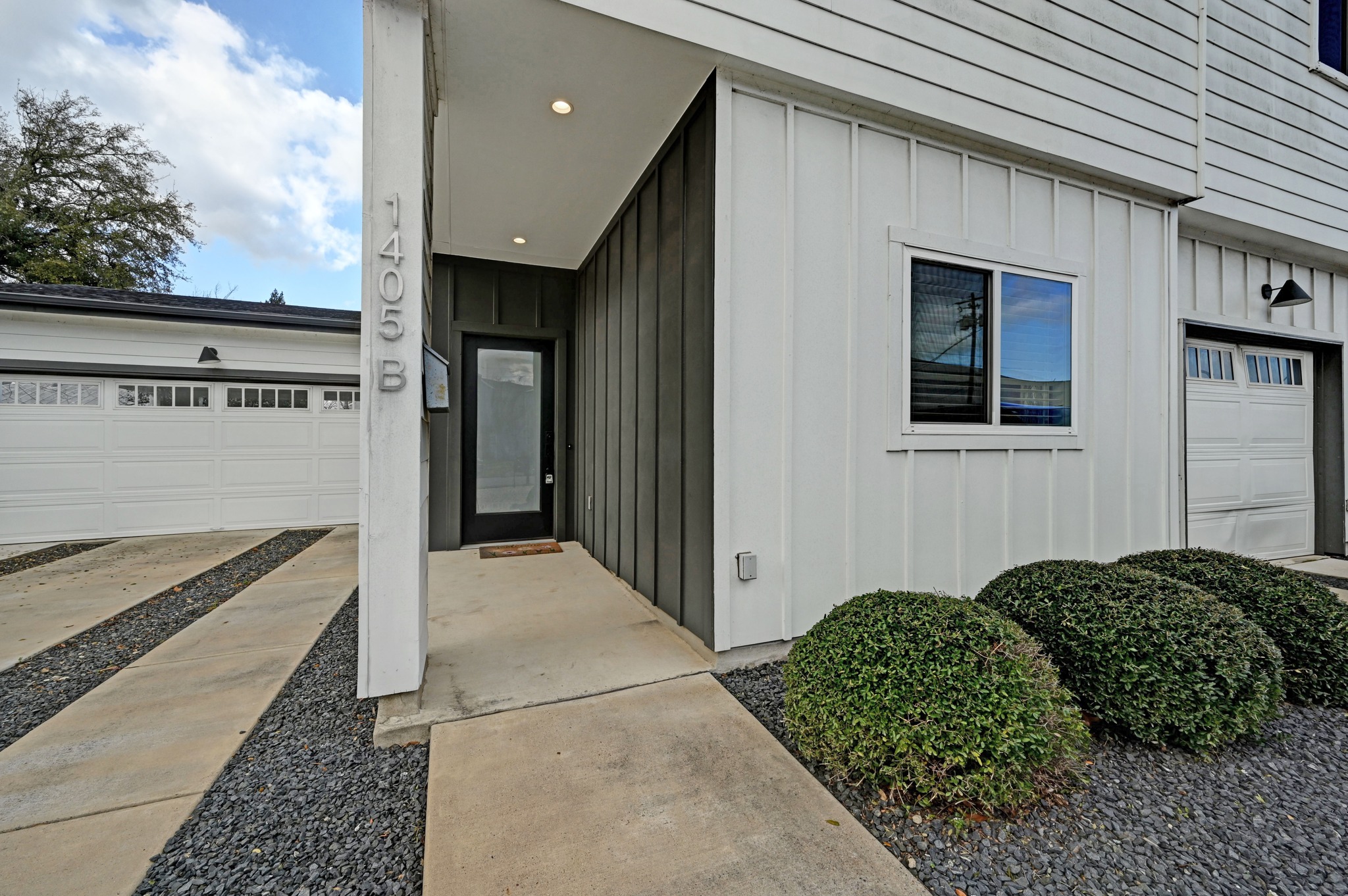 1405 Casey Street, Unit B Austin, TX 78704 - Photo 28 of 28 View of exterior entry with board and batten siding, a garage, and concrete driveway