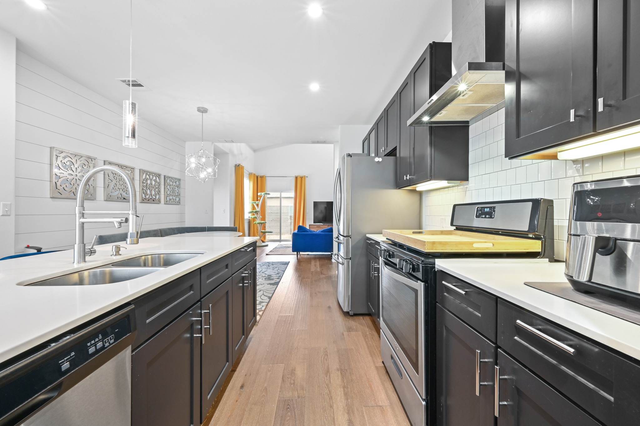1405 Casey Street, Unit B Austin, TX 78704 - Photo 4 of 28 Kitchen featuring stainless steel appliances, light wood-style floors, and dark cabinetry