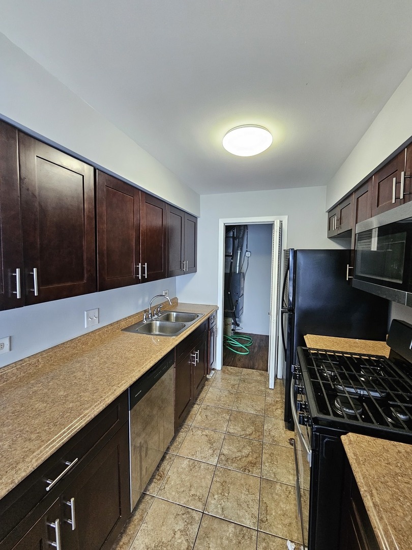 61 Red Barn Road, Unit 1 Matteson, IL 60443 - Photo 4 of 13 a kitchen with stainless steel appliances granite countertop a stove a sink and a refrigerator