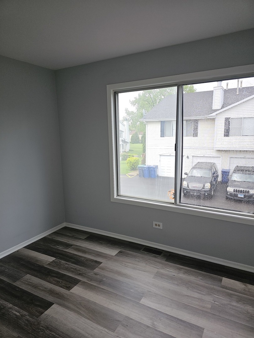 61 Red Barn Road, Unit 1 Matteson, IL 60443 - Photo 6 of 13 a view of empty room with wooden floor and fan