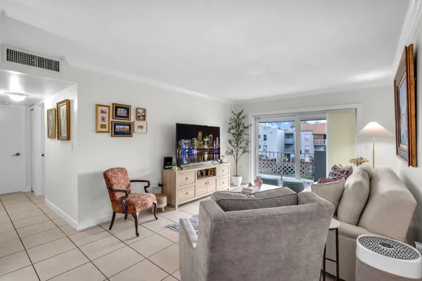 a living room with furniture a flat screen tv and a window