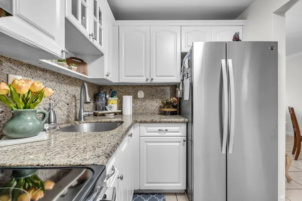 a kitchen with granite countertop a refrigerator and a sink