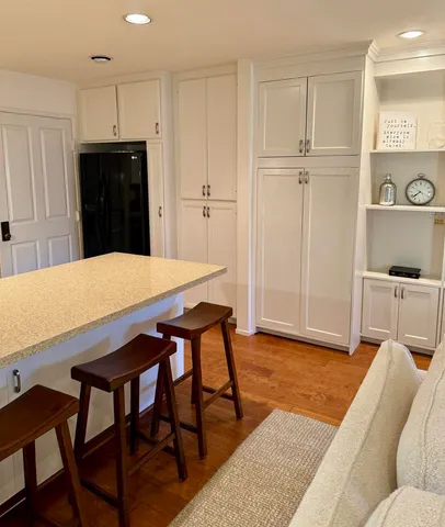 a living room with furniture and a refrigerator