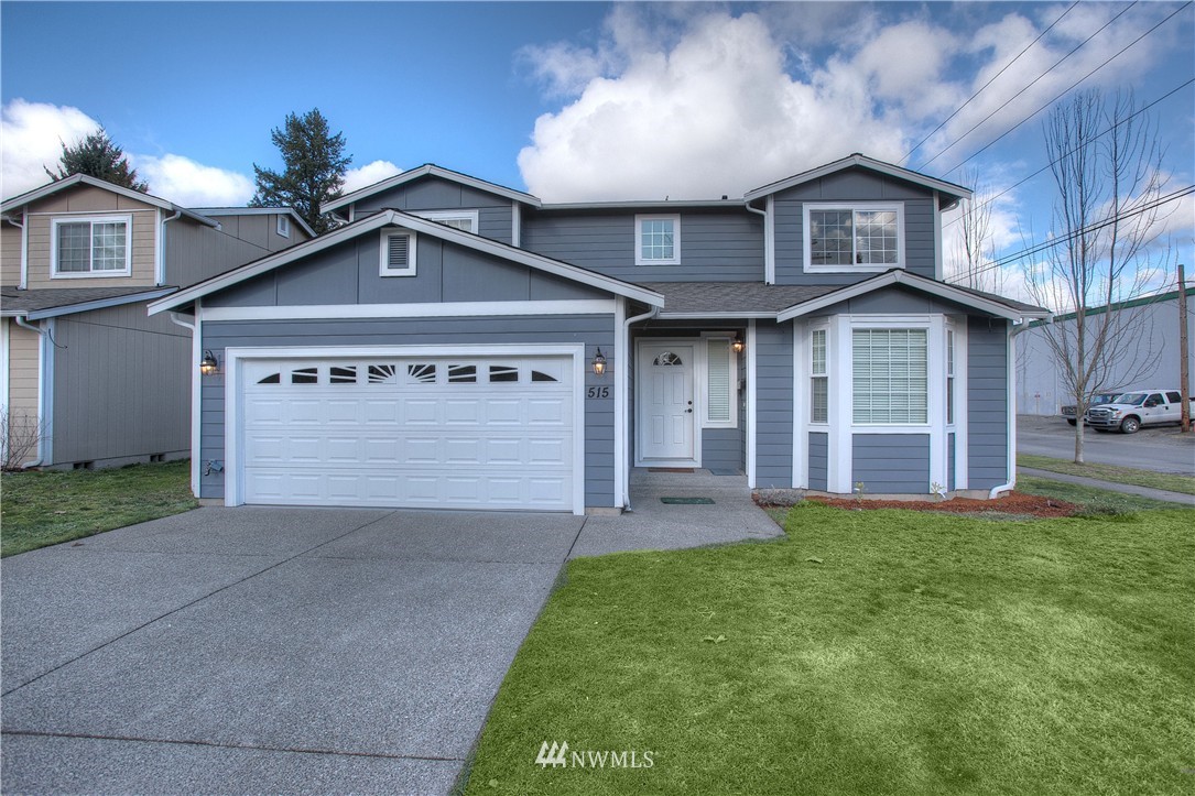 515 Harrison Street Sumner, WA 98390 - Photo 1 of 25 a front view of a house with a yard and garage