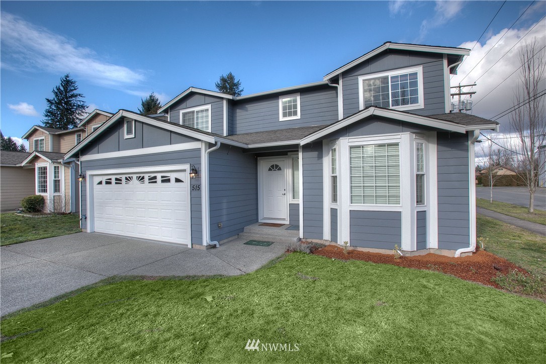 515 Harrison Street Sumner, WA 98390 - Photo 2 of 25 a front view of a house with a yard and garage