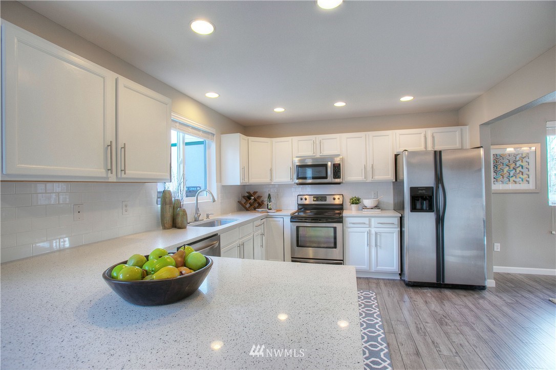 515 Harrison Street Sumner, WA 98390 - Photo 11 of 25 a kitchen with stainless steel appliances kitchen island granite countertop a refrigerator and microwave