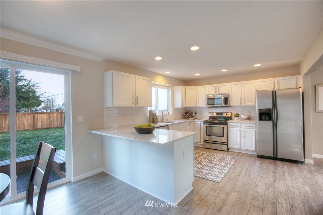 515 Harrison Street Sumner, WA 98390 - Photo 10 of 25 a kitchen with white cabinets and appliances