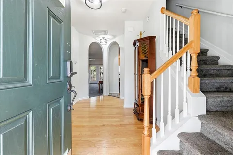 a view of staircase with lots of frames on wall and wooden floor
