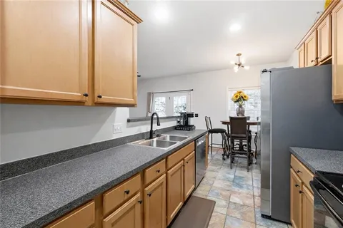 a kitchen with granite countertop a sink a stove and cabinets